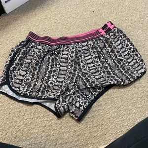 Grey, black and pink Under Armour running shorts.